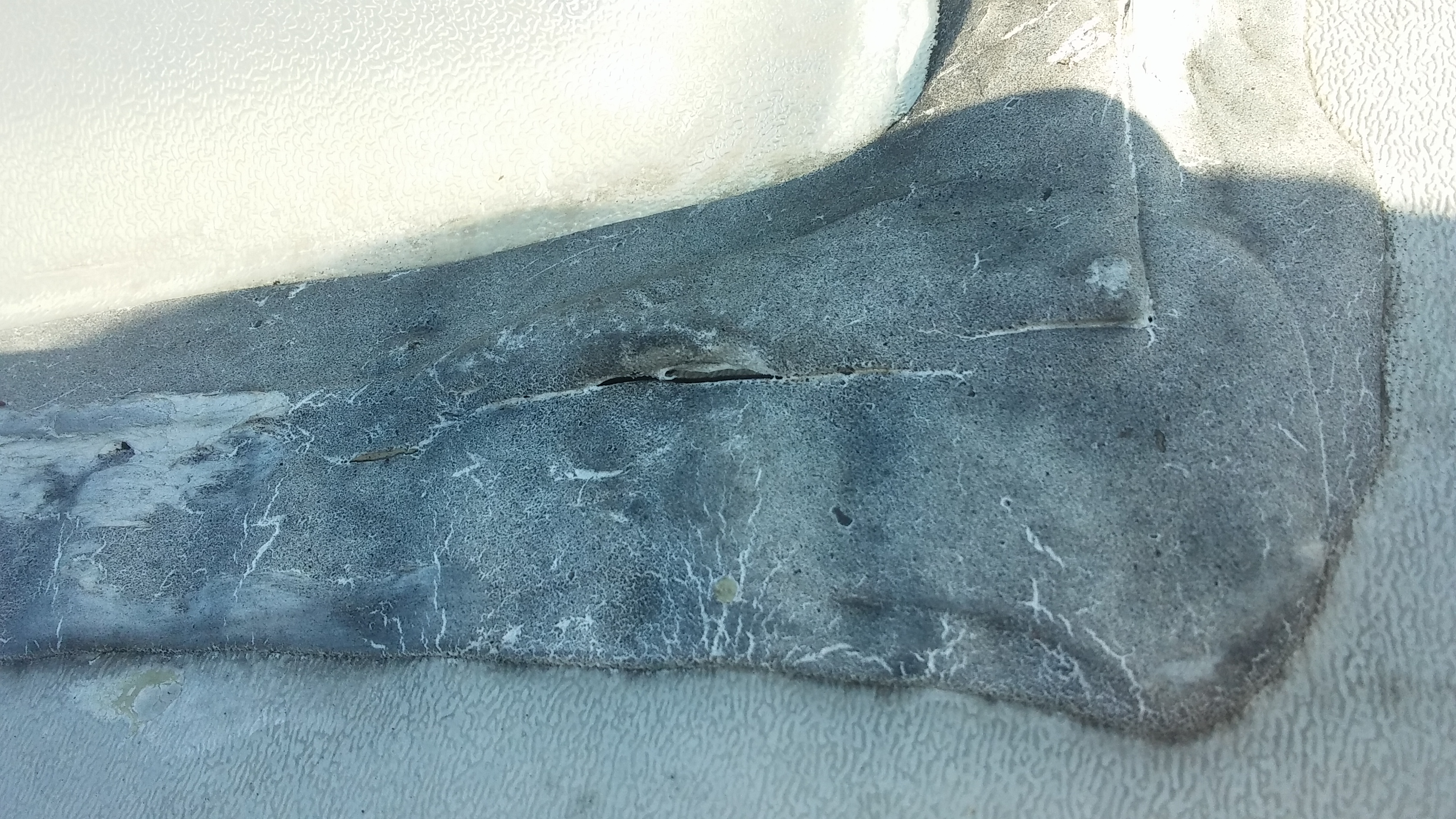 Sun-rotted, cracked and chalky factory roof sealant on an RV termination bar before resealing